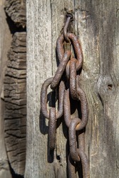Rusty steel chain. An old iron chain on a background of wood.