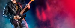 Guitar player performs on stage. Rock guitarist plays solo on an electric guitar. Artist and musician performs like rockstar. 
