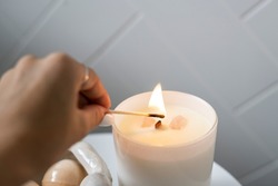 Burning White Candle, alight flames of wick, white candle lit, woman burning match to light candle, lighting flame. 