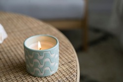 Green and White candle, patterned candle alight, candle flames lit, burning candle, coastal interiors burning flame.