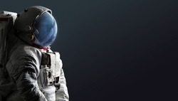 Astronaut isolated on dark background. Spaceman with space and stars in helmet. Creative sci-fi space wallpaper. Elements of this image furnished by NASA