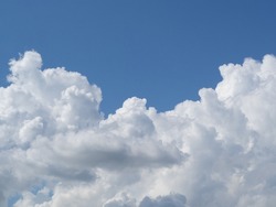 A big white fluffy cloud in the blue sky. the sky with a large cloud is lonely for the background. A Big White Cloud In The Sky In Summer