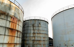 Old and rusted steel silos for storage of solids and liquids.