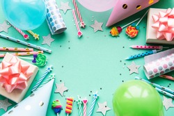 Happy birthday or party background.  Flat Lay wtih birthday balloons , confetti and ribbons on pastel green background. Top View.  Copy space.