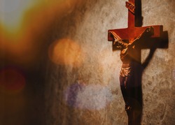 Crucifix of Jesus Christ hang on Concrete wall with  Bokeh light, christian background with copy space