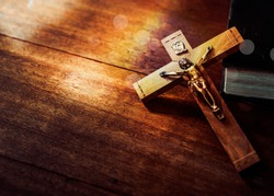 Jesus's crucifix over bible on wooden table background,Christian world mission concept,  copy space