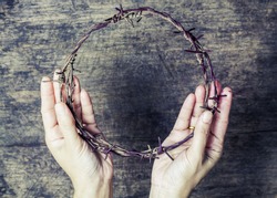 A lady hands holding old metal Barbed Wire made like the crown of thorns of Jesus  can be used for Christian concept , easter concept