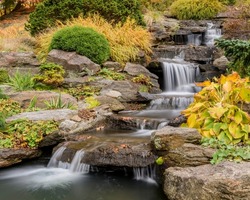 Milky flowing waterfall cascading through beautiful rocks and fall foliage.
