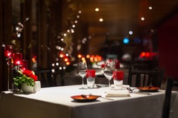 romantic dinner setup, red decoration with candle light in a restaurant. Selective focus.