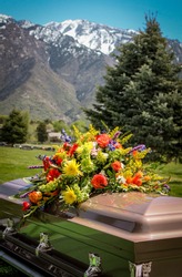 casket with flowers and mountain background