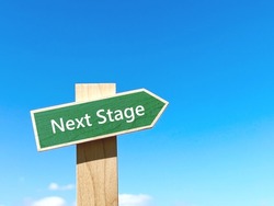 Next Stage text green signpost in blue sky and right space