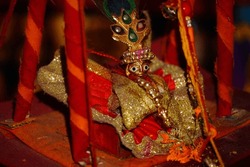 Lord Krishna also known as laddu gopal sculpture in beautiful clothes selective focus