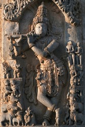 Stone Sculpture of Hindu God Krishna with selective focus, 12th century Hindu temple, Ancient stone art and sculptures in each pillars, Chennakeshava Temple, Belur, Karnataka, India.