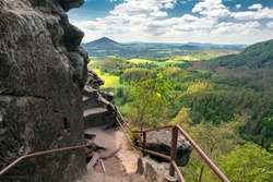 Epic view from Rock of Maria, or Mariina skala, or Marienfels into beautiful landscape of Bohemian Switzerland on a sunny summer day. View from the top of the rock into vast, picturesque landscape.