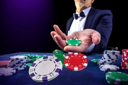 Gambling concept. Close up of casino bettor male hand throwing Сasino chips or Casino tokens at gambling club. Dice, poker cards, gambling man lucky guy spending time in games of chance at casino.