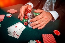Gambling concept. Close up of Poker Player male hand Winning Royal Flush at casino, gambling club. Сasino chips or Casino tokens,  dice, poker cards, gambling man lucky guy, games of chance.