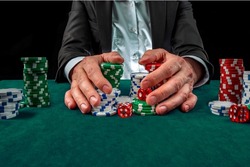 Gambling concept. Close up of Poker Player male hand Winning at casino, gambling club. Сasino chips or Casino tokens,  dice, poker cards, gambling man lucky guy, games of chance.