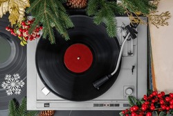 Turntable Vinyl records, Christmas party music, New Year events, fir branches, top view. Empty copy space for record label mockup. Vintage retro sound recording style. Background for the design.