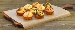 Salty and tasty muffins, baked and decorated with seeds toper placed on the wooden table, bakery ideas 