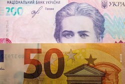 Poland — March 09 2022: In this photo illustration 50 euro note and Ukrainian 200 hryvnias banknote with the image of Lesya Ukrainka are seen displayed.