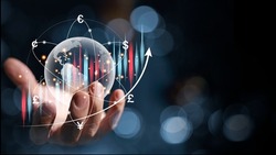 A businessman hand holding a hologram globe and have a virtual line of currency flows around it and a graph showing the ups and downs of forex trading, the concept of global currency exchange.
