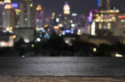 Wood floor with blurred abstract background of city night lights downtown city view : Wooden table with blur background of cityscape