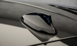 Modern design sport car radio antenna on the carbon roof also known as shark fin.