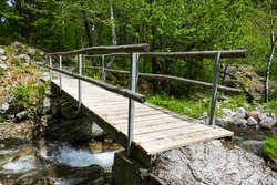 Small wooden pedestrian bridge for hikers, over a stream in the Verzasca valley near Brione (Ticino, Switzerland).