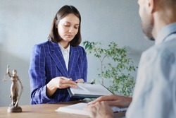 soft selective focus, female lawyer at a meeting with a male client in the office of the law office, legal advice online. resolution of disputes of the family code during divorce and division of