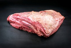 Raw dry aged wagyu beef shoulder clod roast as closeup on black background with copy space 
