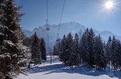 Winter Mountain landscape with ski lift in snowy forest recreation ski resort area in Bavaria, Germany on sunny day