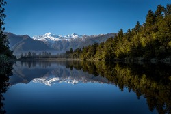 Lake Matheson. The reflection of sunrise over Mt.Cook through the lake.
It is one of the most famous lake in West Coast next to Fox Glacier / New Zealand.