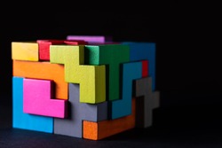 Cube made of multicolored wooden geometric shapes. Concept of decision making process, creative, logical thinking. Choose correct answer. Logical tasks. Conundrum.