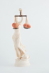 Lady Justice holds scales with heart and brain on isolated white background. Punishment balanced between emotions and rationality. Critical concept of law or human head. Making good decisions.