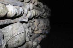 Dark and shocking wall of human skulls on black background