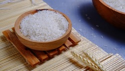 Rice in a wooden bowl with some neat and simple kitchen ornaments giving an elegant and attractive impression. food and beverage concept. rice is a symbol of prosperity.