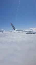 Aicraft wing in air during a flight over London United Kingdon against cloudy sky