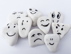Emotion management concept, stones with painted faces symbolize different emotions. We are all different, but all together, learning to manage emotions. Soft background, white stones.