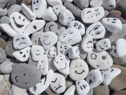 Emotion management concept, stones with painted faces symbolize different emotions. We are all different, but all together, learning to manage emotions. Emotional intelligence, role model. Good mood.