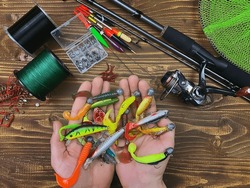 Fishing tackle. Float, wobbler, bait hooks, on a wooden background. Selective focus