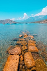 Ruins of the wall in the beach in Phaselis ancient city in Antalya Turkey. Tourism in Turkey. Beaches of Turkey. Bey mountains on the background. 