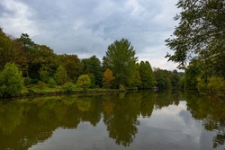 Pond or lake in the forest at autumn or fall with cloudy sky. Fall season background photo. Ataturk Arboretum in Istanbul.