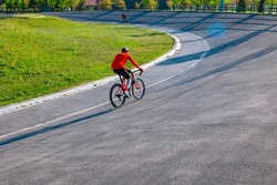 A cyclist with red jerseys on the cycle-racing track for training. Healthy lifestyle or bicycling or training concept photo. Motion blur on the cyclist.