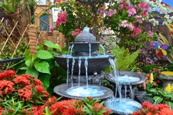 Antique fountain at garden. Blue water flowing from stone fountain. Design of antique fountain