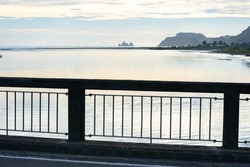 Bridge railing with view along Uawa River to coast in background, Tolaga Bay New Zealand.