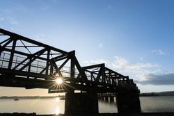 Sunrise glows through Tauranga Railway bridge silhouette