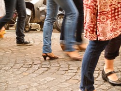 Legs and shoes blurred in movement while walking along cobbled street in Montmartre, Paris France.