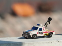 Diecast car toys on the wall with blurred background.