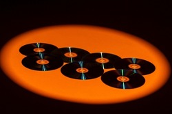 Variety of Arranged CD Disks or DVD Disks on Orange Background With Different Circular Patterns or Masks.Horizontal image