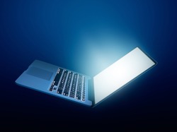 Open laptop with glowing light on dark background